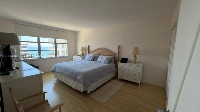 A bedroom features a bed, two nightstands, a desk, and a window with an ocean view — 5161 Collins Ave # 1702, Miami Beach FL 33140, MIAMI BEACH, FL