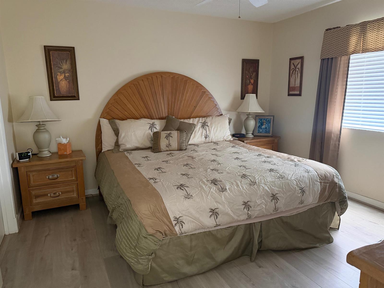 A bedroom features a wooden sunburst headboard, palm tree bedding, and two matching nightstands — 353 S US Hwy 1 # f208, Jupiter FL 33477, JUPITER, FL