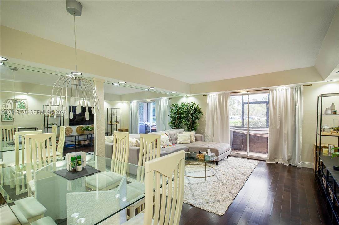 A dining area with a glass table flows into a living room with a sectional — 7100 Nova Dr # 104A, Davie FL 33317, DAVIE, FL