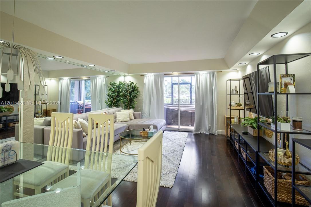 A living room features dark wood floors, a sectional sofa, and a glass dining table — 7100 Nova Dr # 104A, Davie FL 33317, DAVIE, FL
