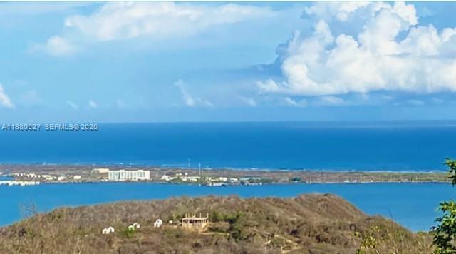 A high-angle view of a coastal landscape with a body of water and distant buildings — 3 el santuario, ba, ba