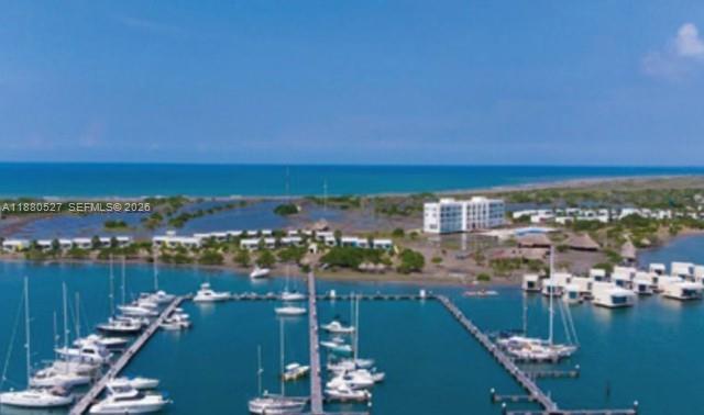 An aerial view shows a marina with docked sailboats and a resort on the coast — 3 el santuario, ba, ba