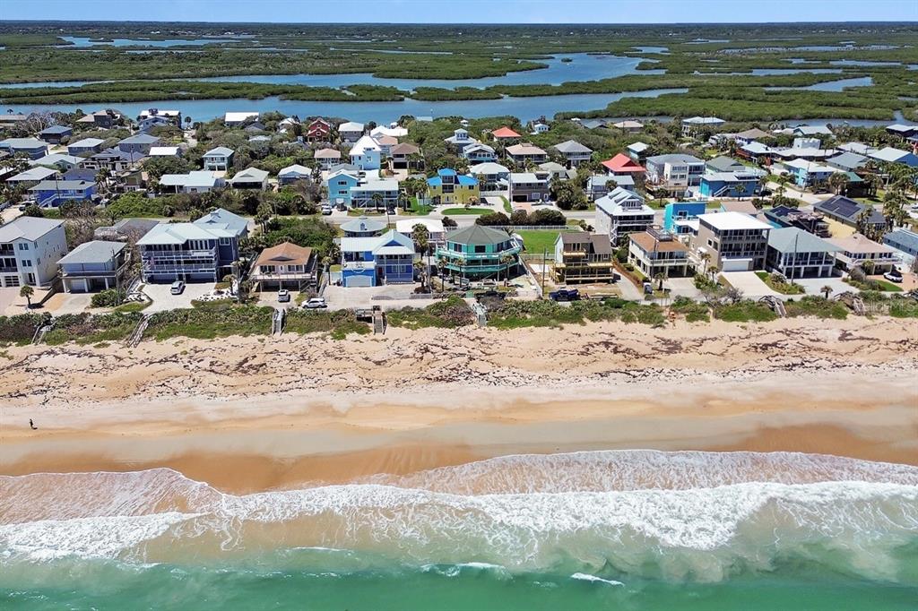 An aerial view of beachfront houses along a sandy coastline with a bay in back — 6344 S ATLANTIC AVENUE, NEW SMYRNA BEACH, FL