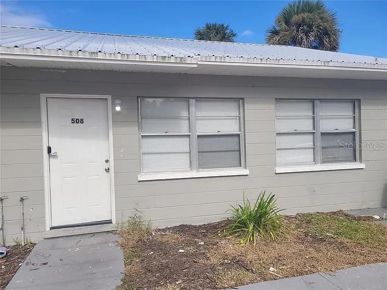 The exterior of a single-story building features a white door, two windows, and a metal roof — 508 BOOKER STREET, TITUSVILLE, FL