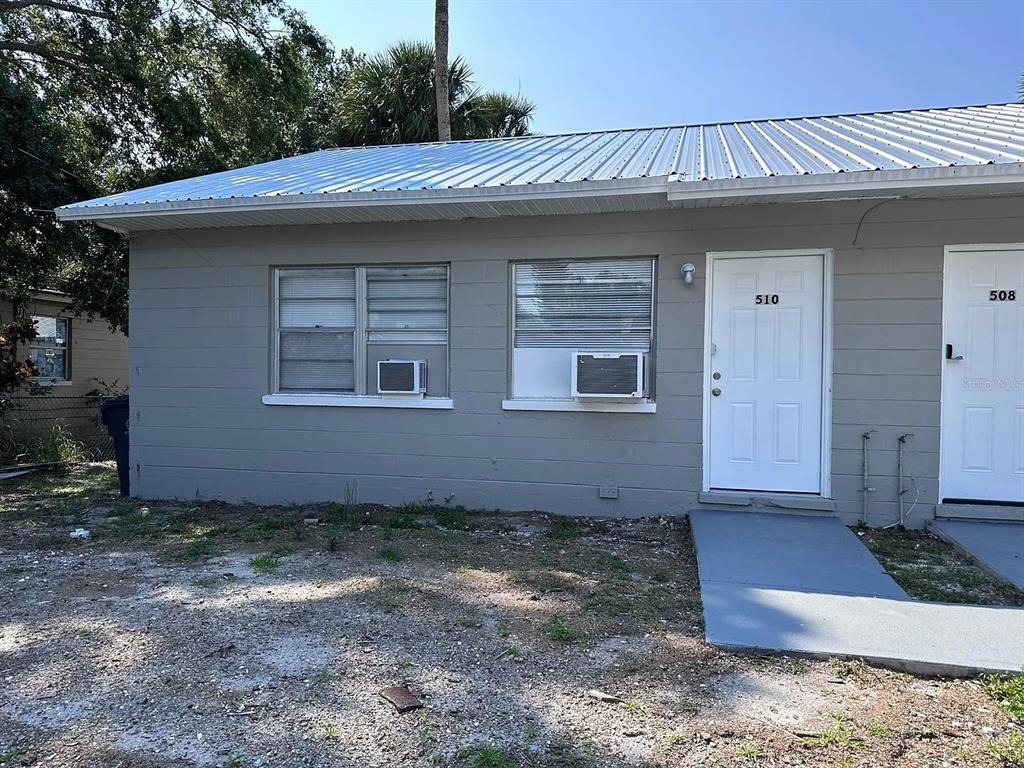 A gray, single-story building exterior features two white doors and two windows with air conditioners — 508 BOOKER STREET, TITUSVILLE, FL