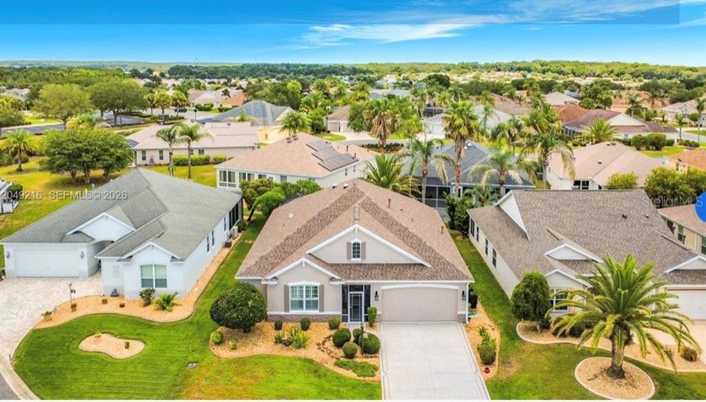 An aerial view of a suburban house with a tan exterior and a shingled roof — 1637 WESTMINSTER COURT, THE VILLAGES, FL