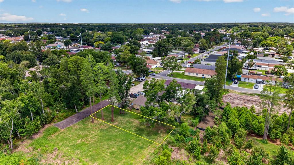 An aerial view shows a rectangular vacant lot outlined in yellow near a residential neighborhood — 6817 N BLOSSOM AVENUE, TAMPA, FL