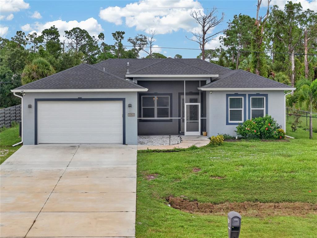 A single-story gray house with a white garage door and a front entry walkway — 1264 S SALFORD BOULEVARD, NORTH PORT, FL