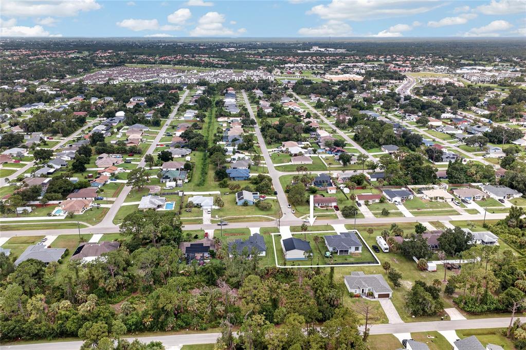 An aerial view shows a residential neighborhood with a highlighted single-family home and surrounding properties — 1264 S SALFORD BOULEVARD, NORTH PORT, FL