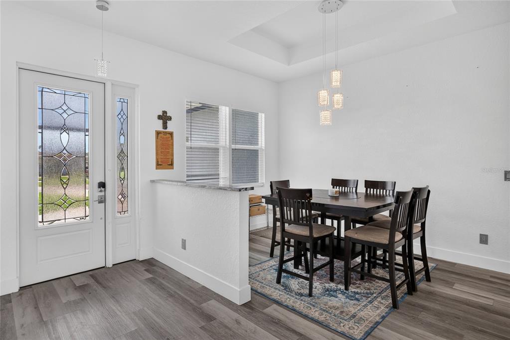 A dining area features a dark wood table with six chairs on a patterned rug — 1264 S SALFORD BOULEVARD, NORTH PORT, FL