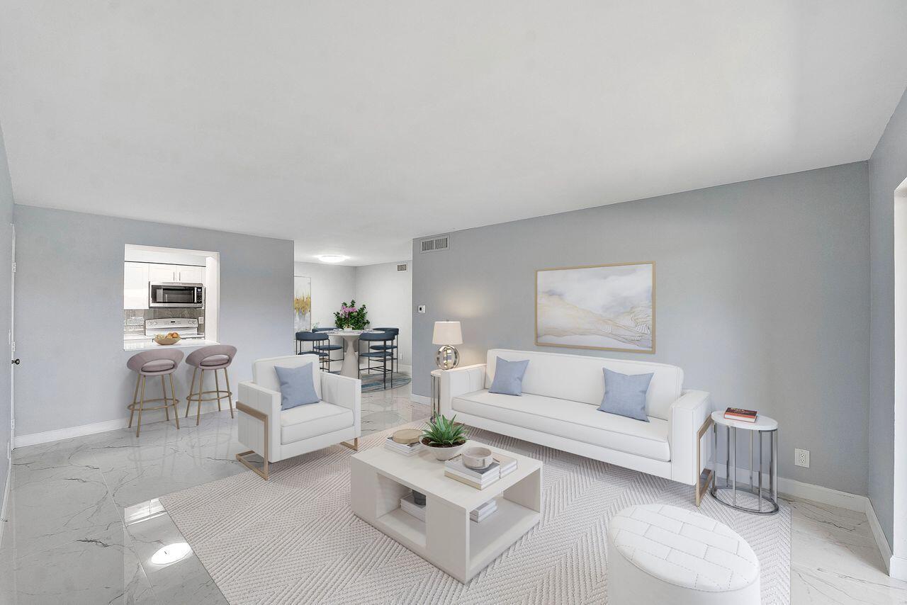 A living room features a white sofa, a matching armchair, and a central coffee table — 9960 Pineapple Tree Drive # 107, Boynton Beach FL 33436, BOYNTON BEACH, FL