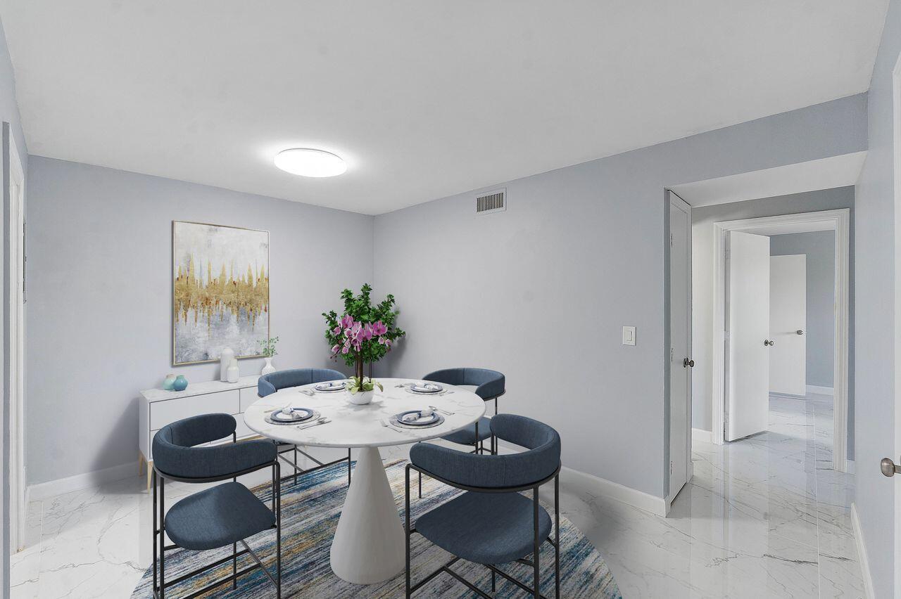 A dining room features a round marble table, blue chairs, and white marble flooring — 9960 Pineapple Tree Drive # 107, Boynton Beach FL 33436, BOYNTON BEACH, FL