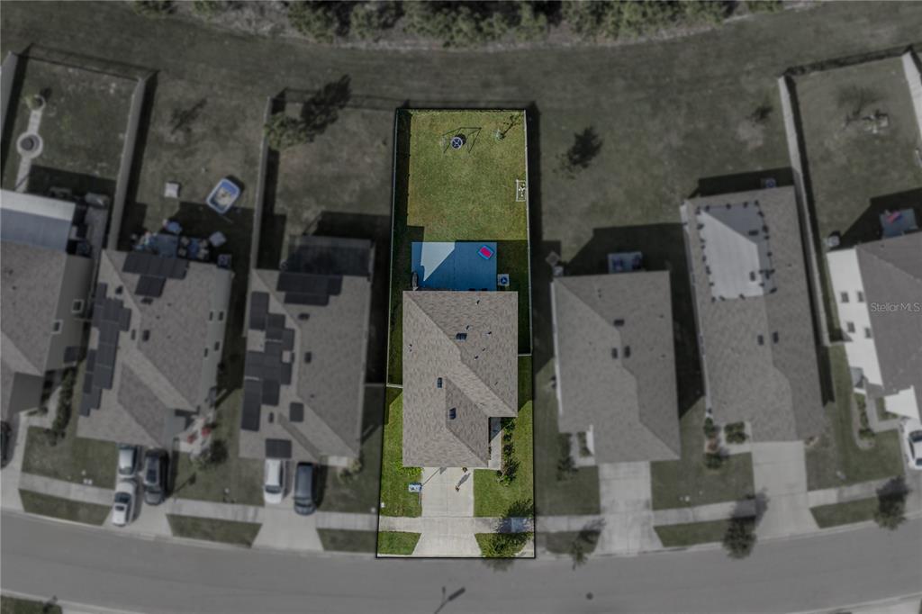 An aerial view shows a single-family home with a fenced backyard and driveway — 10951 PENNY GALE LOOP, SAN ANTONIO, FL