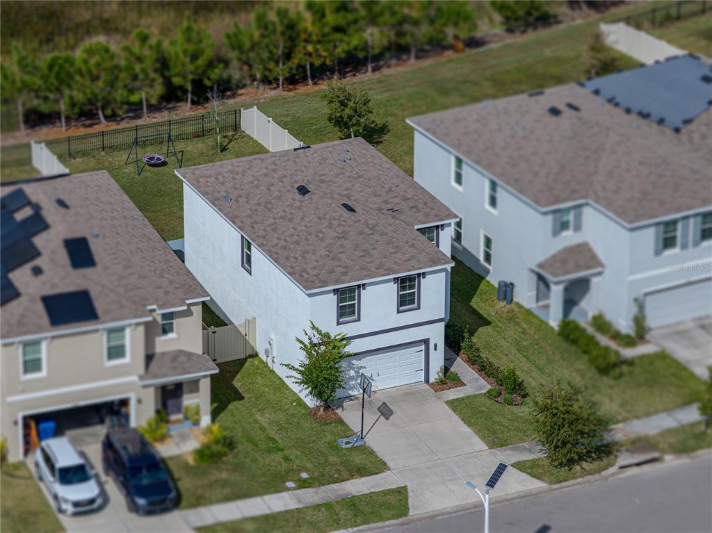 An aerial view shows a two-story suburban house with a driveway and a fenced backyard — 10951 PENNY GALE LOOP, SAN ANTONIO, FL