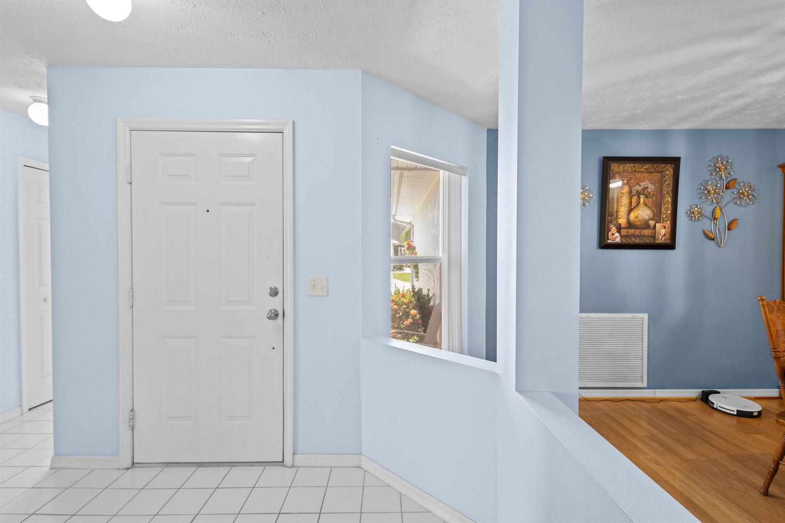 An entryway features a white front door, light blue walls, and a partial wall divider — 6527 Alheli, Fort Pierce FL 34951, FORT PIERCE, FL