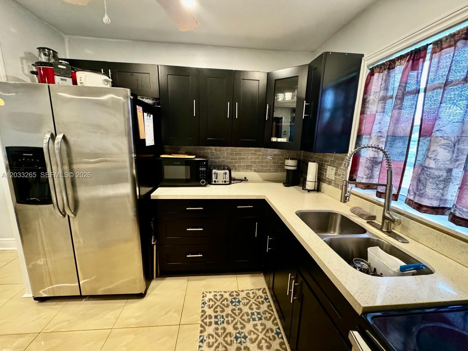 A kitchen features dark wood cabinets, stainless steel appliances, and light-colored countertops — 5300 Washington St # H236, Hollywood FL 33021, HOLLYWOOD, FL