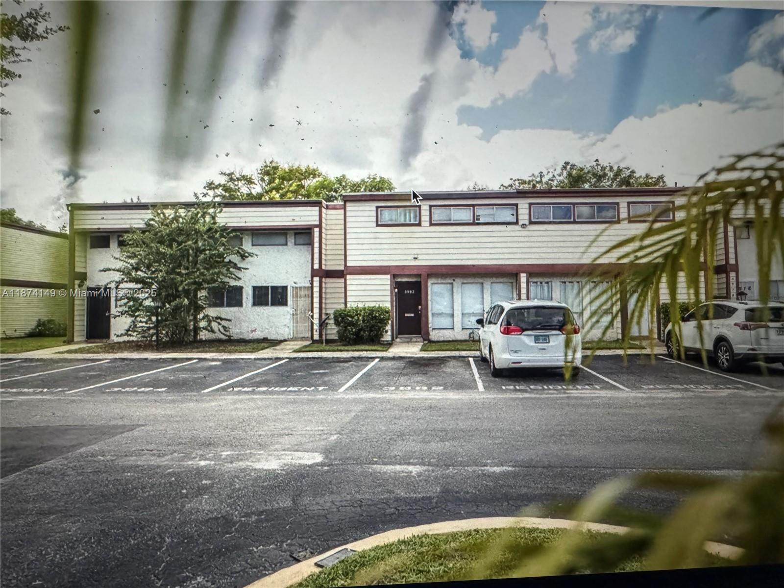 A two-story apartment building exterior with a parking lot and two parked cars — 3984 Crayrich Circle # C5, Orlando FL 32839, ORLANDO, FL