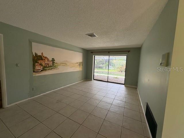 An empty room features light-colored floor tiles, pale green walls, and a large wall mural — 4240 CHARING CROSS ROAD, SARASOTA, FL