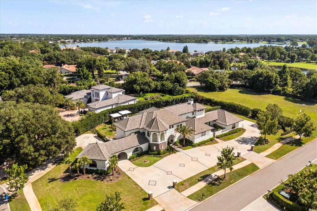 An aerial view of a large estate with a multi-winged house and a lake nearby — 12237 PARK AVENUE, WINDERMERE, FL