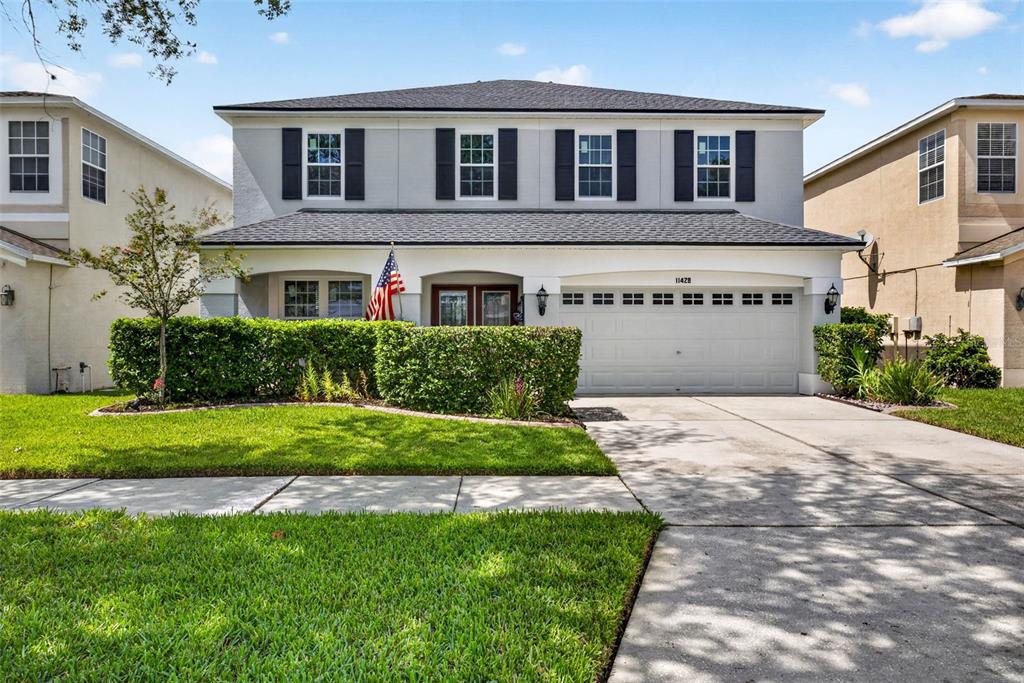 A two-story suburban house with a gray exterior, black shutters, and a two-car garage — 11428 BLUE LILAC AVENUE, RIVERVIEW, FL