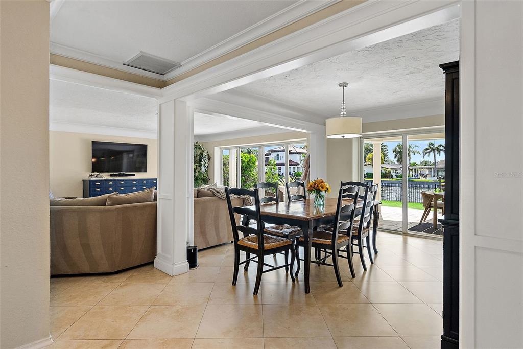 A dining area with a wooden table and chairs sits adjacent to a living room — 1985 CAROLINA AVENUE NE, ST PETERSBURG, FL