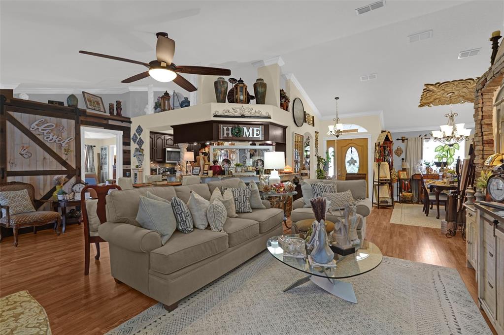 A living room features a beige sofa, a glass coffee table, and a kitchen area — 3279 COUNTRYSIDE VIEW DRIVE, ST CLOUD, FL