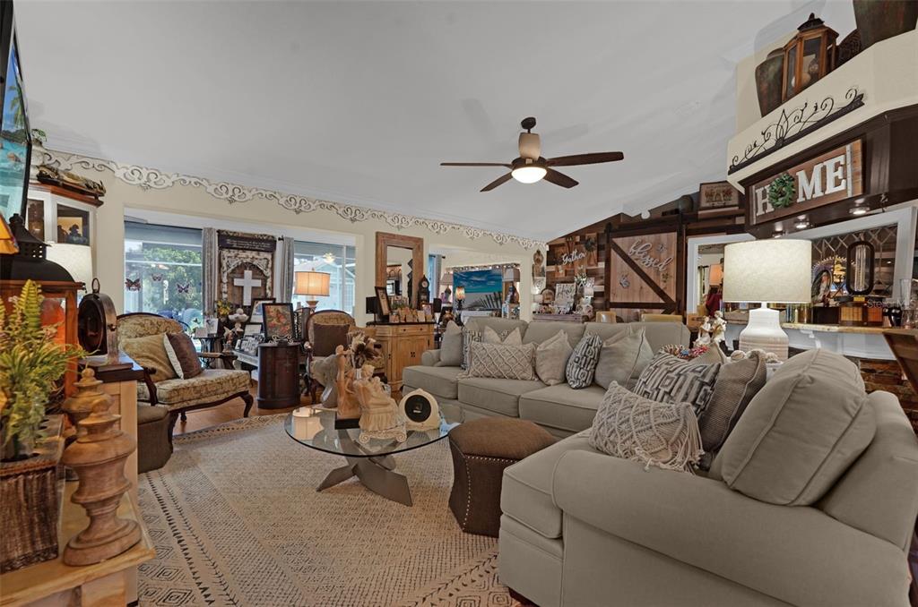 A living room features a beige sectional sofa, a glass coffee table, and rustic decor — 3279 COUNTRYSIDE VIEW DRIVE, ST CLOUD, FL