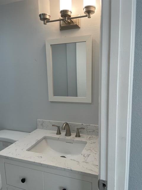 A bathroom vanity with a white cabinet, marble-look countertop, and a rectangular wall mirror — 6905 69th Way, West Palm Beach FL 33407, WEST PALM BEACH, FL