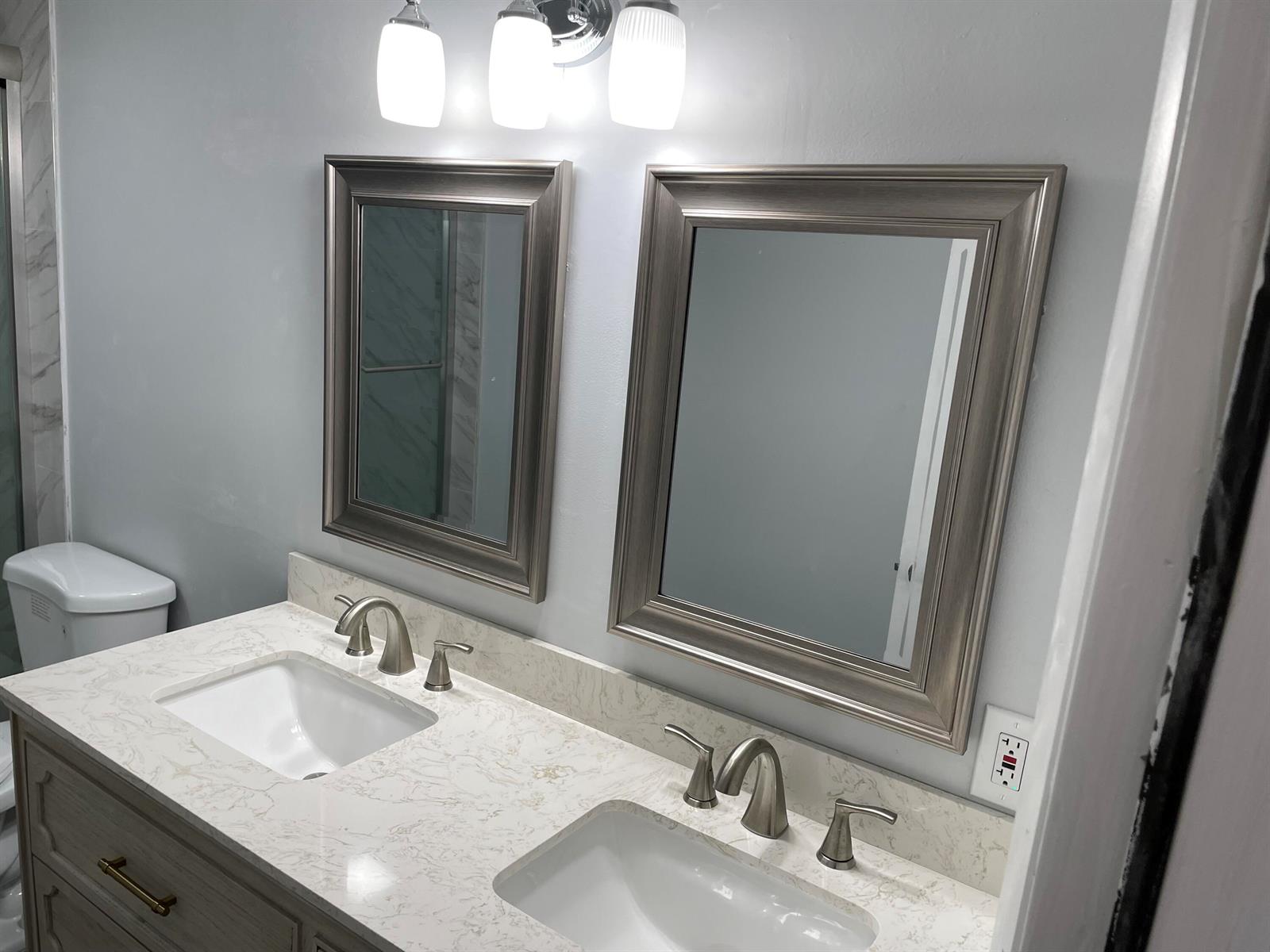 A bathroom vanity features two framed mirrors, dual sinks, and brushed nickel fixtures — 6905 69th Way, West Palm Beach FL 33407, WEST PALM BEACH, FL