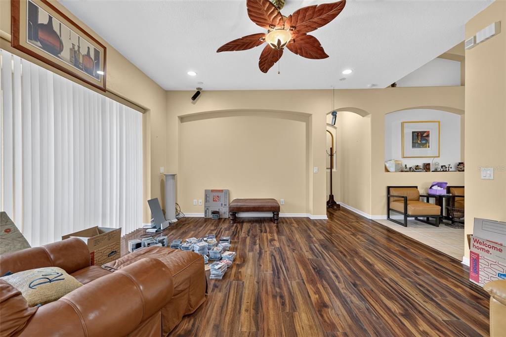 A living room features wood-look flooring, a ceiling fan, and an arched wall niche — 316 HARTS OAK PLACE, SEFFNER, FL
