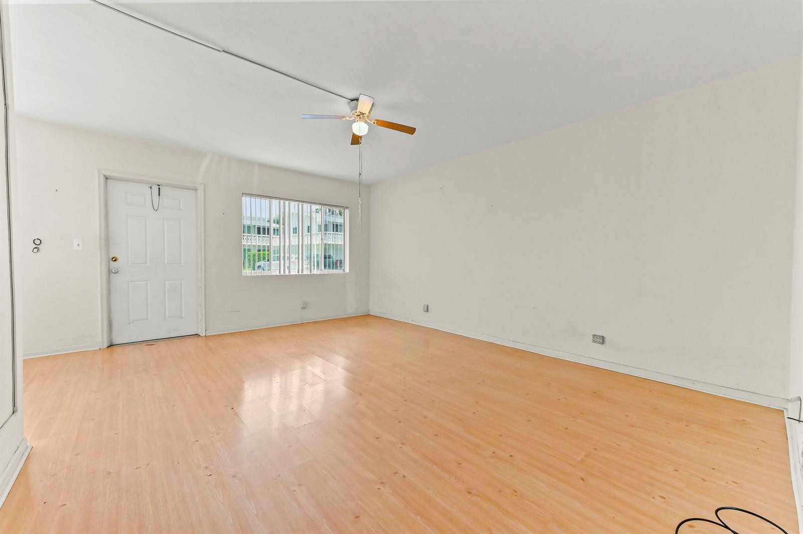 An empty room features light wood-look flooring, white walls, a ceiling fan, and a window — 1950 Lake Osborne Drive # 9, FL 33461, FL