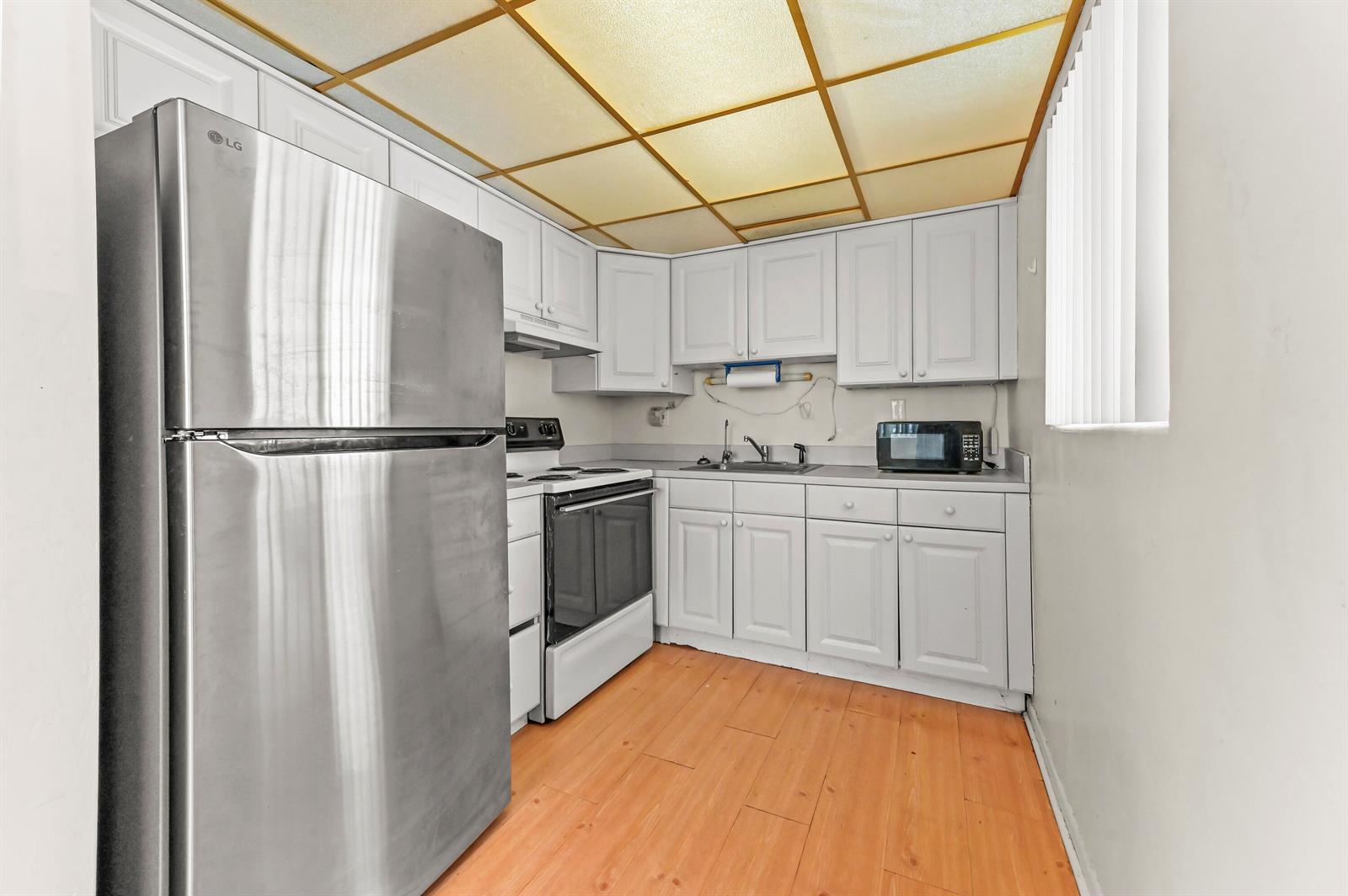 A kitchen features white cabinets, stainless steel appliances, and a grid-patterned drop ceiling — 1950 Lake Osborne Drive # 9, FL 33461, FL