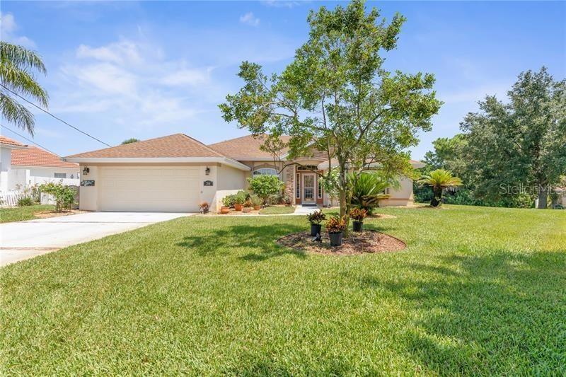 A single-story house with a two-car garage, a large front lawn, and a central tree — 30 COLERIDGE COURT, PALM COAST, FL