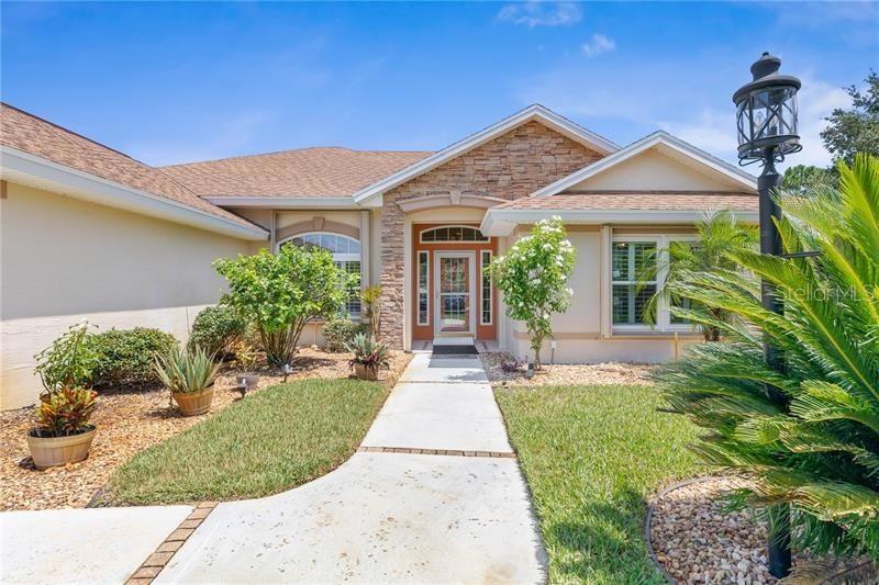 A single-story house features a stone-accented facade, a concrete walkway, and a front yard — 30 COLERIDGE COURT, PALM COAST, FL