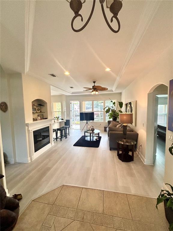 A living room features light wood flooring, a fireplace, a ceiling fan, and a sofa — 30 COLERIDGE COURT, PALM COAST, FL