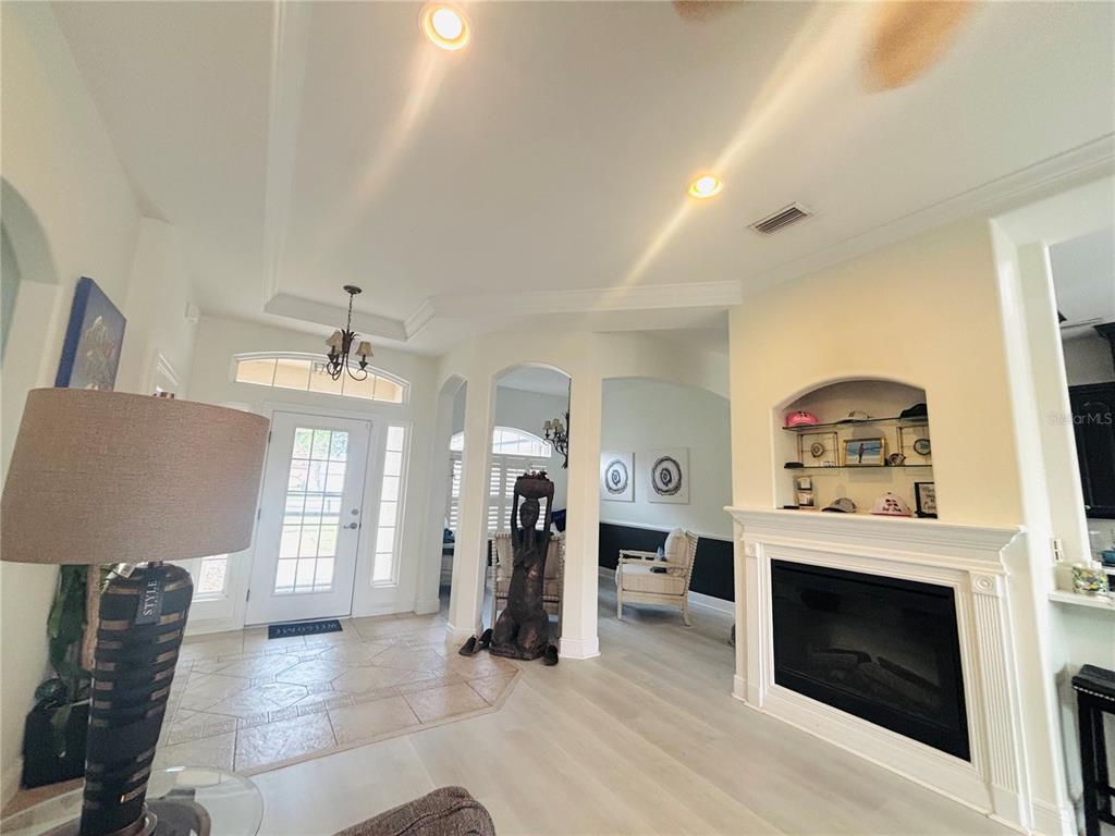 An entryway with tile flooring leads to a living area featuring a fireplace and molding — 30 COLERIDGE COURT, PALM COAST, FL