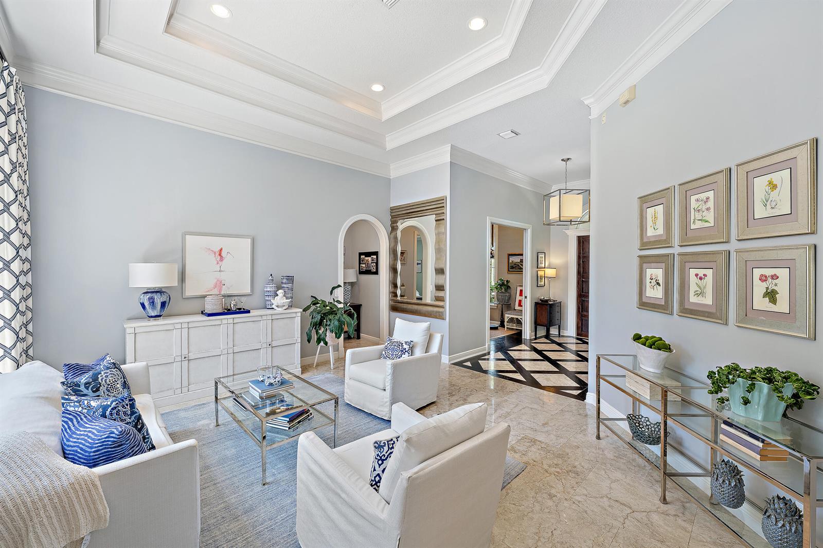 A bright living room features a tray ceiling, marble floors, and blue and white decor — 105 Segovia Way, Jupiter FL 33458, JUPITER, FL