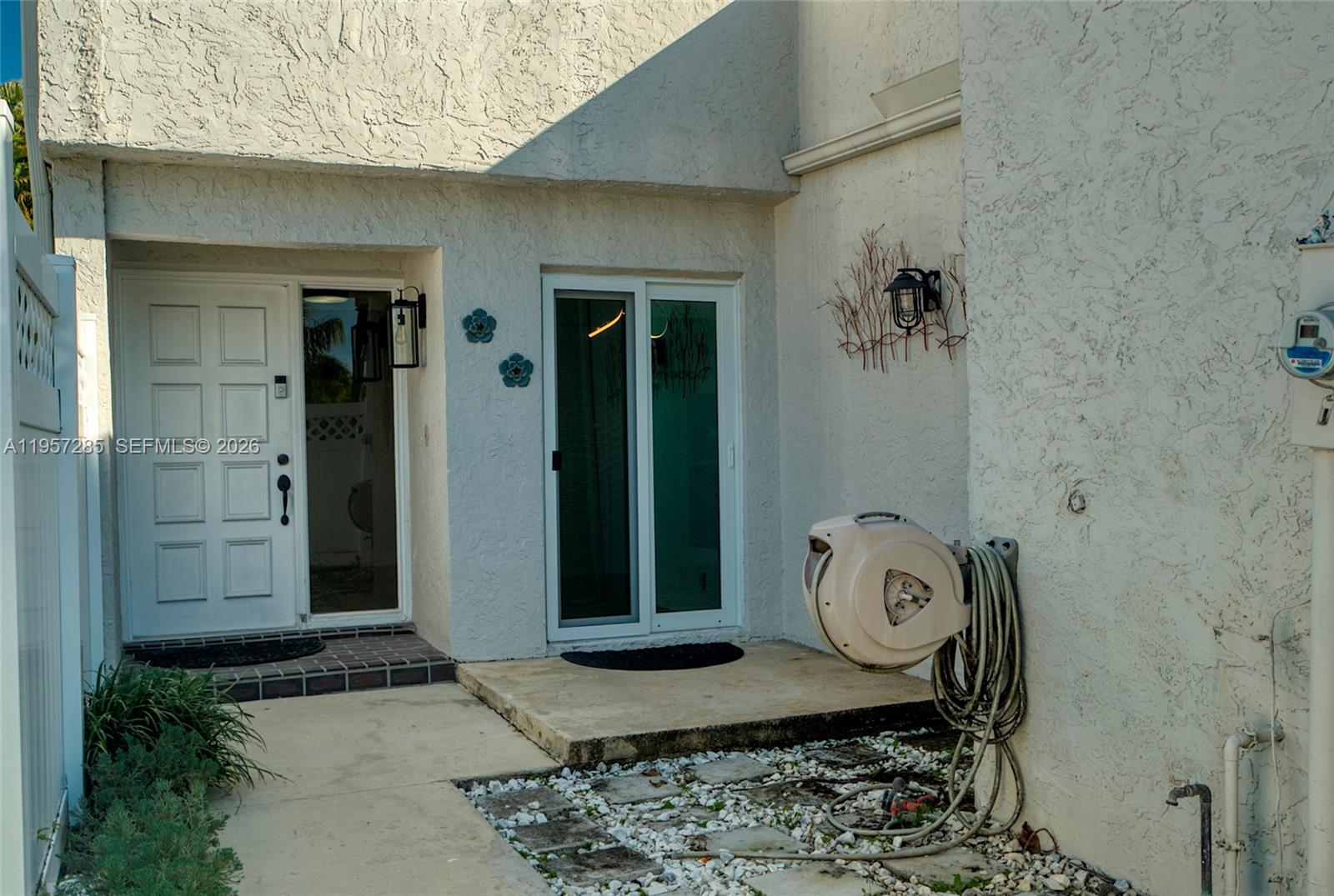 An exterior view shows a white stucco building with a front door and sliding glass door — 6768 Canary Palm Cir, Boca Raton FL 33433, BOCA RATON, FL