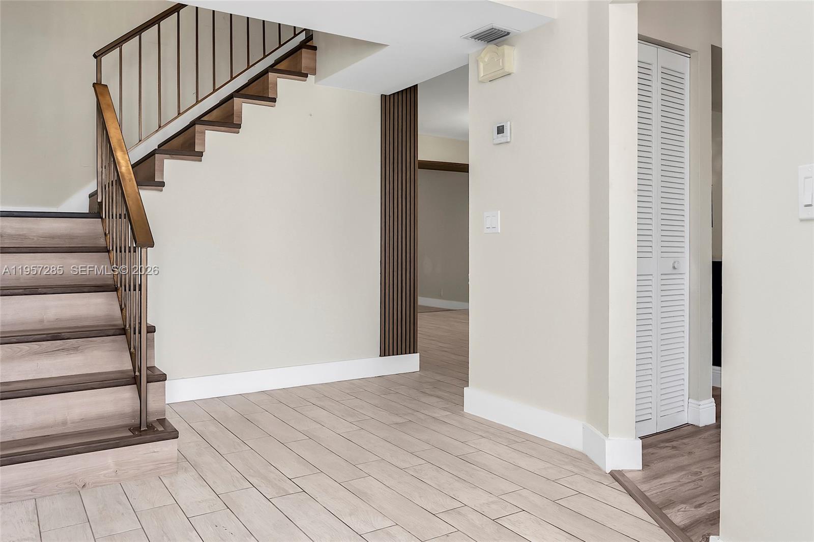 An interior view shows a staircase with wood treads, a slatted wall, and tile flooring — 6768 Canary Palm Cir, Boca Raton FL 33433, BOCA RATON, FL