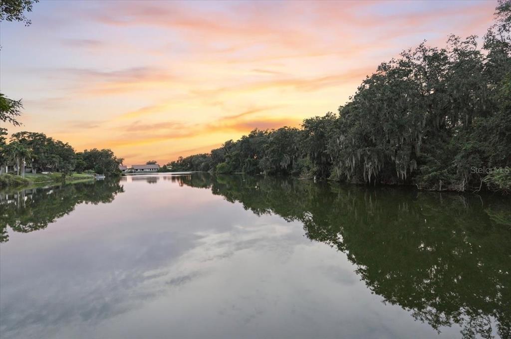 Two wooden chairs sit on a dock overlooking a calm lake at sunset — 448 LAKE HARRIS DRIVE, LAKELAND, FL