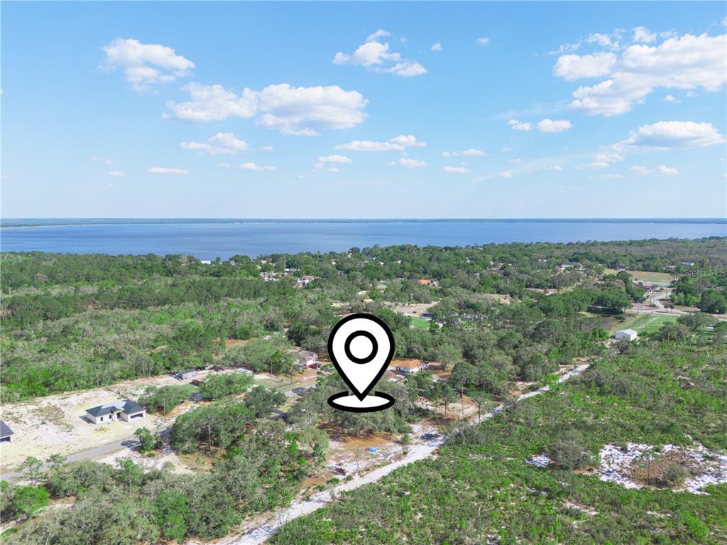 An aerial view shows a wooded lot with a location pin near a large lake — LEMON DRIVE, LAKE WALES, FL