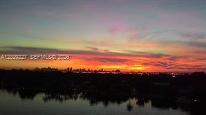 An aerial view shows a waterfront patio with a flag, pool, and boats on the water — 5700 Collins Ave # 8K, Miami Beach FL 33140, MIAMI BEACH, FL