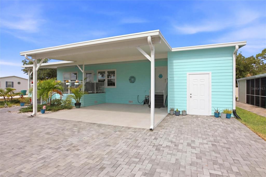 A light blue manufactured home features a covered carport and a paved driveway — 4378 MANATEE LOOP UNIT 19A, PUNTA GORDA, FL