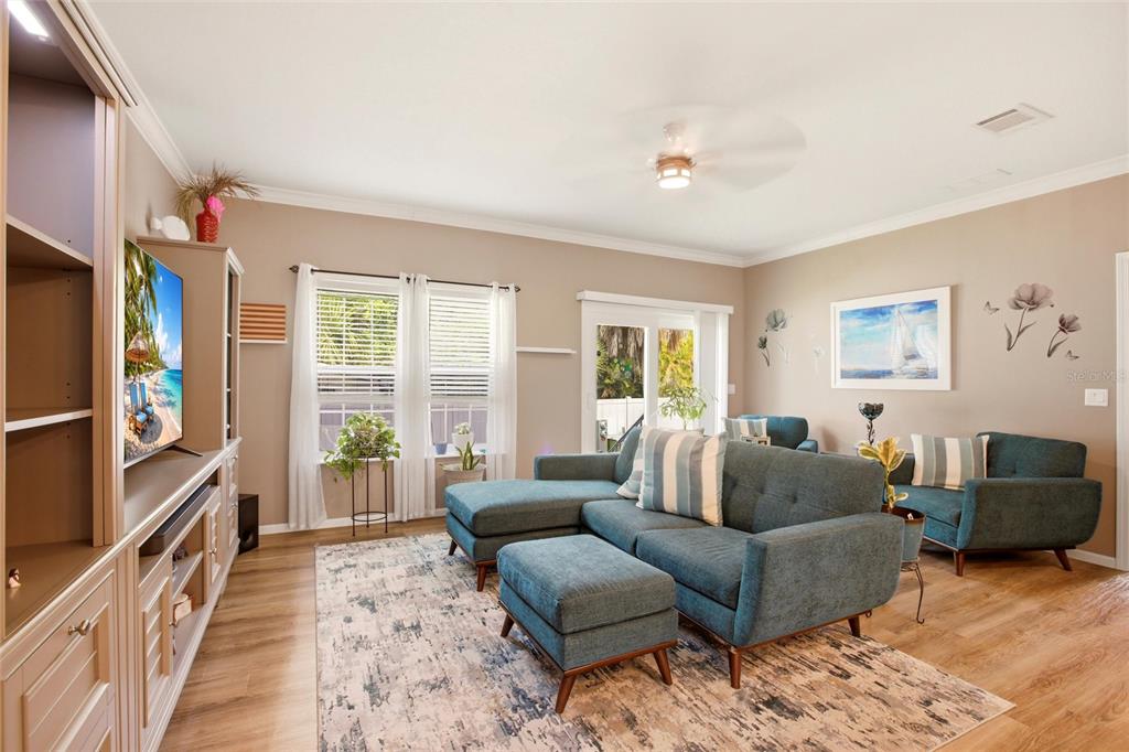A living room features a blue sectional sofa, a matching ottoman, and a large media console — 4378 MANATEE LOOP UNIT 19A, PUNTA GORDA, FL