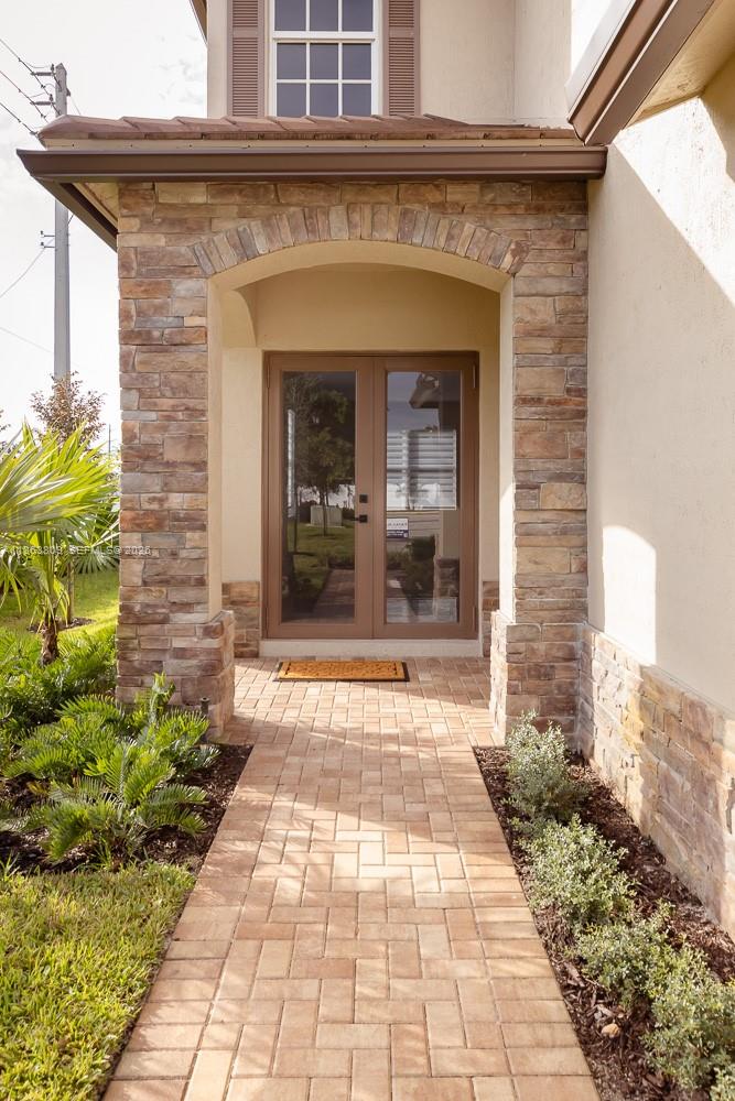 A stone-accented entryway features a brick paver walkway leading to double glass front doors — 5400 NW 57th Ct, Tamarac FL 33319, TAMARAC, FL