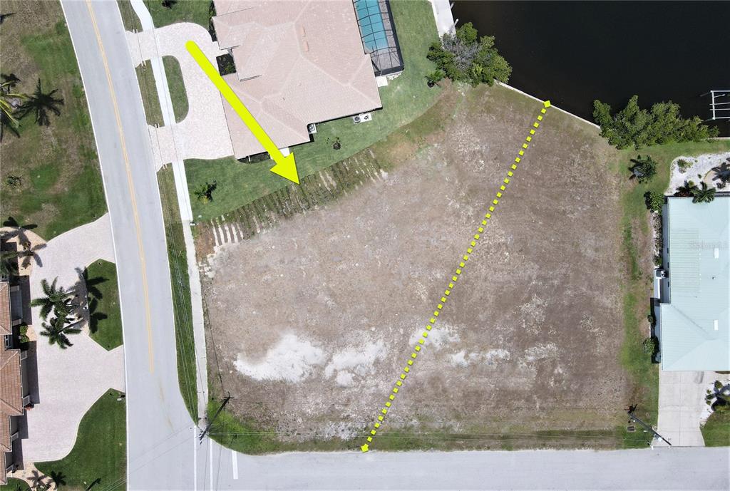 An aerial view shows a vacant, cleared residential lot situated between two existing houses — 3690 WHIPPOORWILL BOULEVARD, PUNTA GORDA, FL