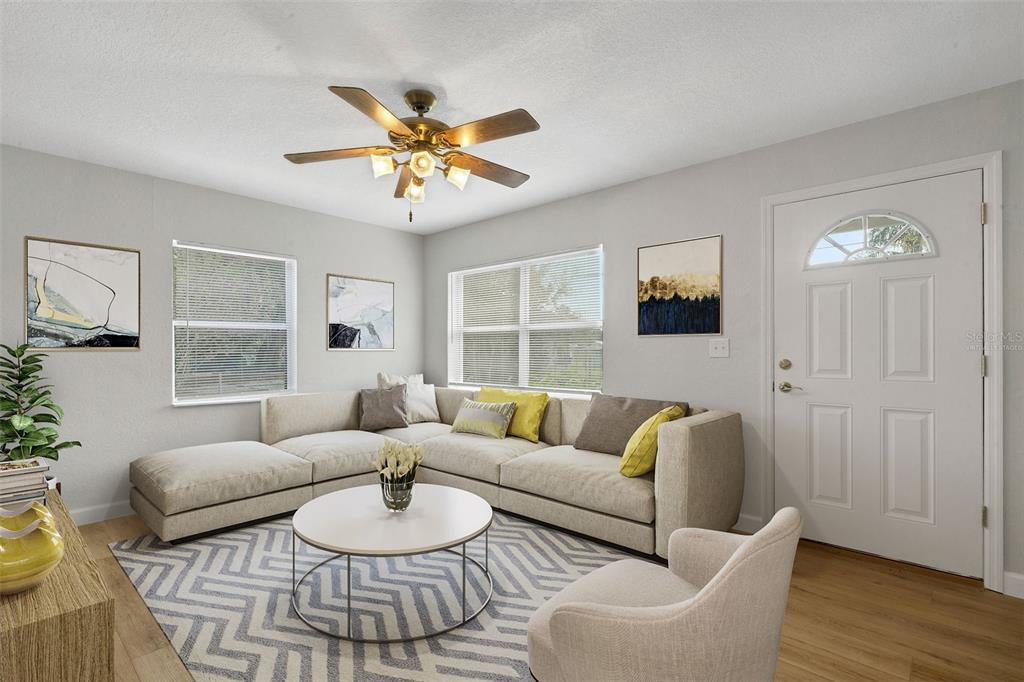 A living room with a sectional sofa, round coffee table, area rug, and ceiling fan — 2716 HARDIN COMBEE ROAD, LAKELAND, FL