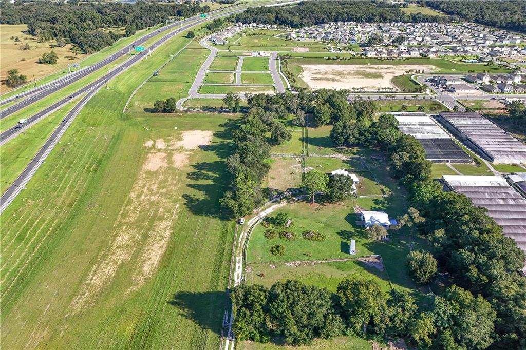 An aerial view shows a rural property with two houses next to a highway and neighborhood — 3243 W KELLY PARK ROAD, APOPKA, FL