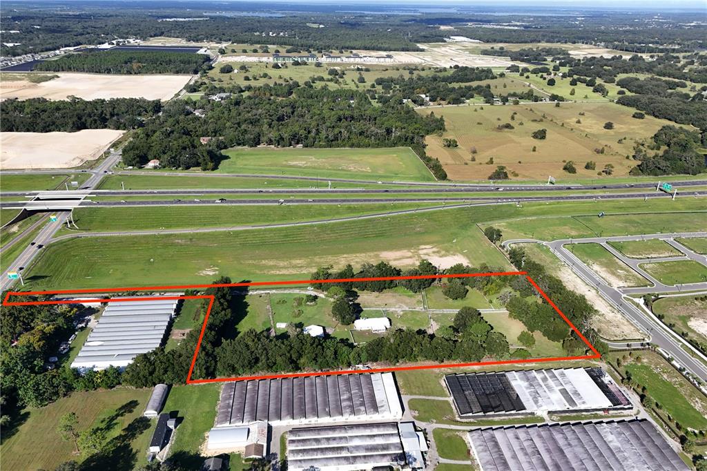 An aerial view shows a rectangular property outlined in red, featuring a house and greenhouses — 3243 W KELLY PARK ROAD, APOPKA, FL