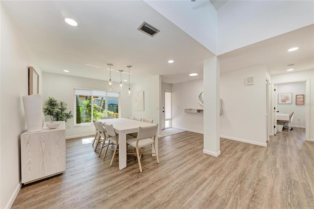 A bright dining room features a white table, modern light fixtures, and wood-look flooring — 6416 WOOD OWL CIRCLE, BRADENTON, FL